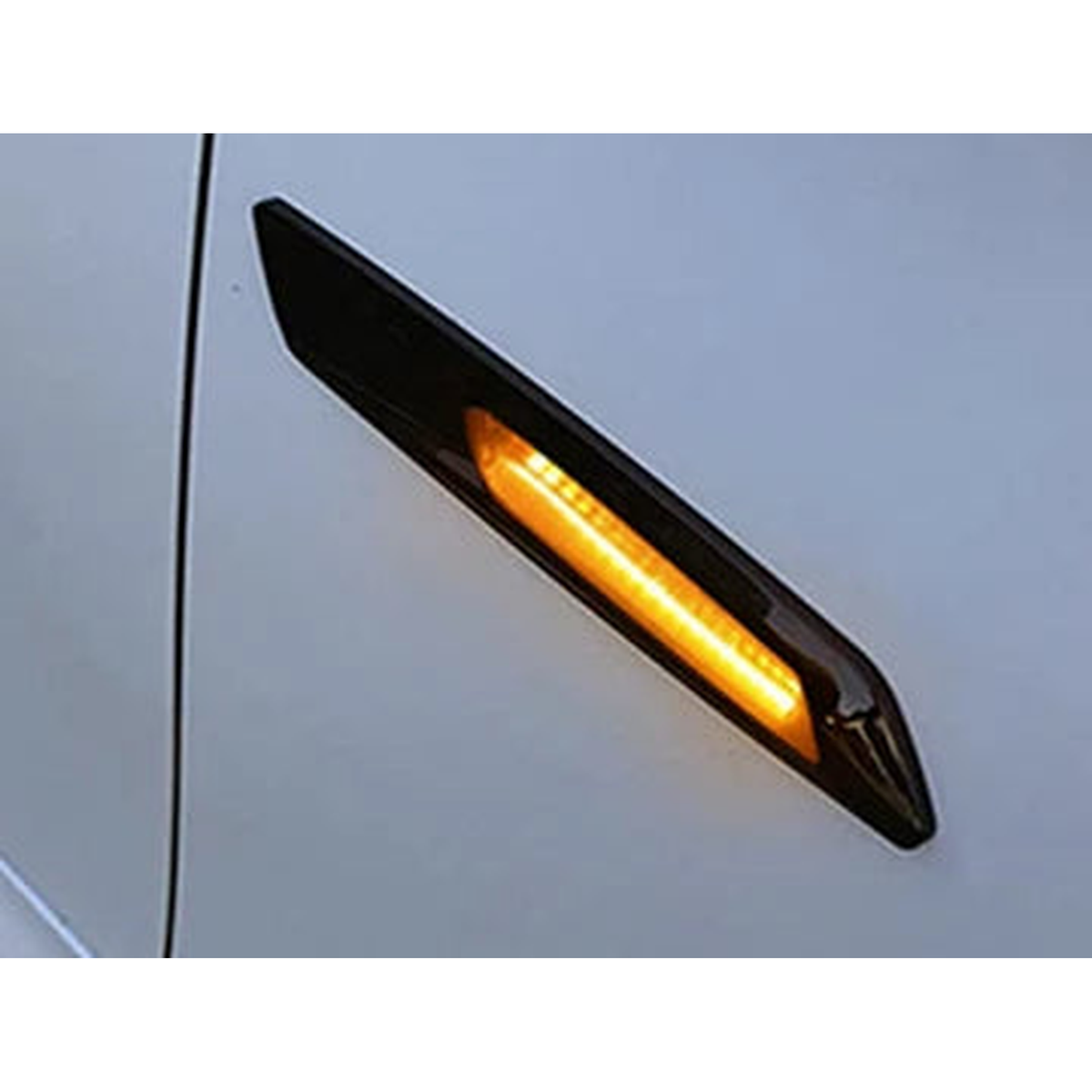 Smoked LED side marker lit amber, fitted on a silver wing, close up, for BMW E90 / E60 / E82 / E87 / E84