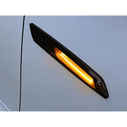 Smoked LED side marker lit amber, fitted on a silver wing, close up, for BMW E90 / E60 / E82 / E87 / E84