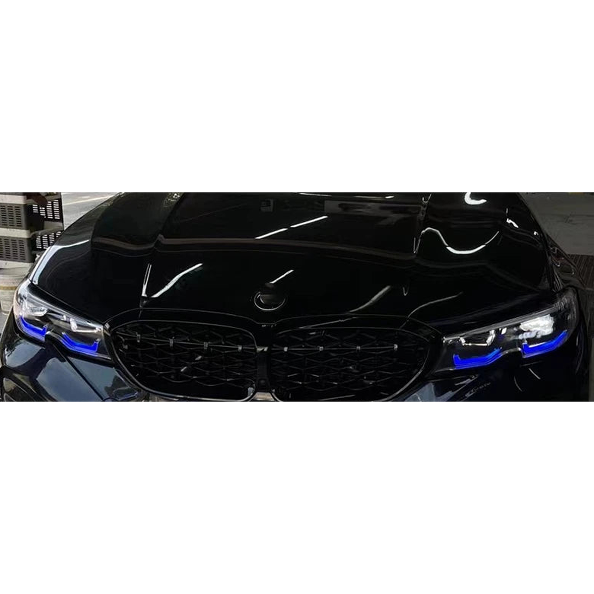 Blue daytime running lights fitted in a black 3 Series, front view, for BMW G20 / G21 LED headlights incl. M340i
