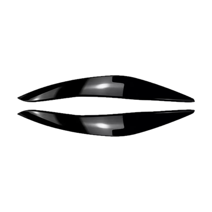 Gloss black headlight eyebrow covers, pair, angled view, for BMW 5 Series F10 Pre-LCI (2010-2013)