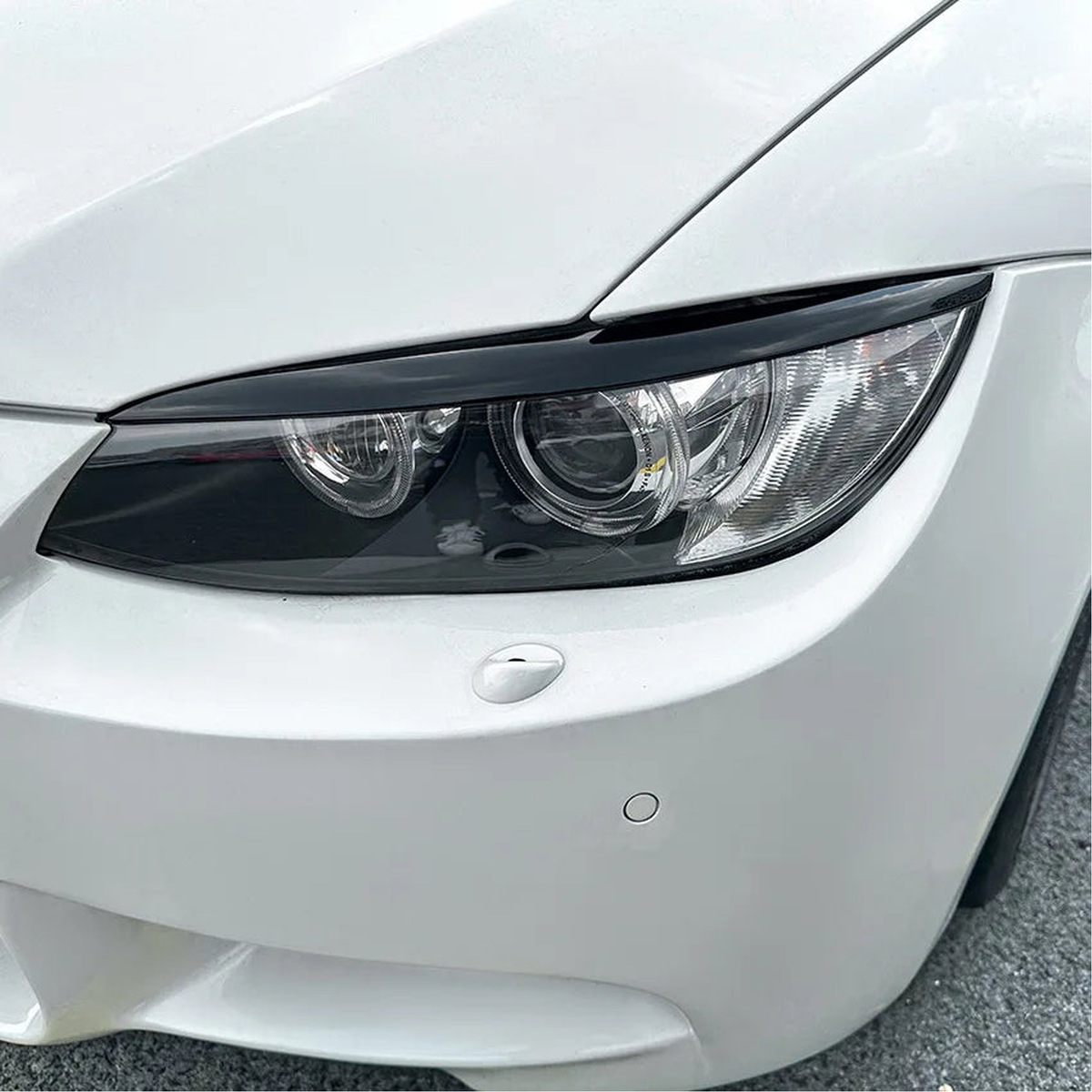 Gloss black headlight eyebrow installed on a BMW E92 / E93 Pre-LCI headlight